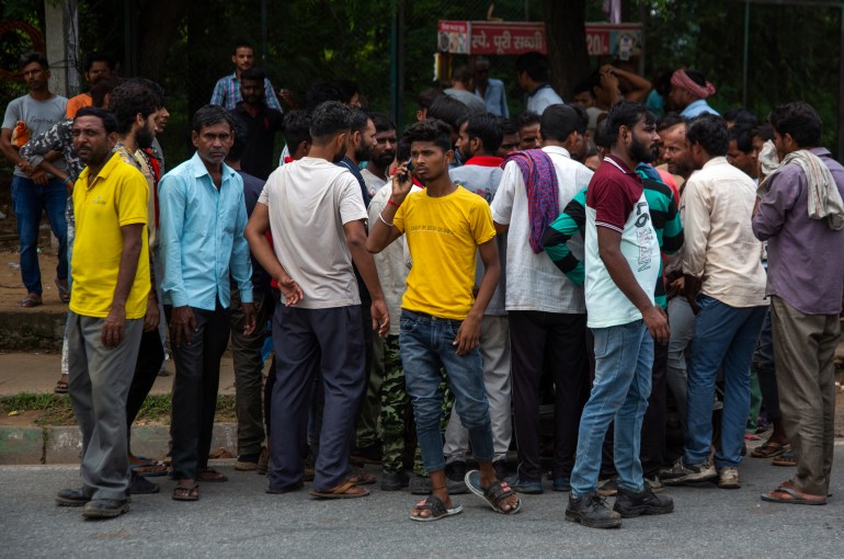 Människor från nordliga stater trängs på arbetskorg - en basar vid korsningen av fyra vägar där hundratals arbetare samlas dagligen vid gryningen för att vädja om arbete i Manesar Industrial Area, Haryana delstaten, Indien,