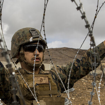 cc US Department of Defense, modified, https://flickr.com/photos/39955793@N07/45440230804/in/photolist-2cep4vf-WdexVB-gGm4hp-6ZnFgM-7biJPt-QTH5Ue-7bnhnm-WaNfG1-93eidn-NBDjfT-uoPJaw-SfpYh4-z6mvgr-7bnuQJ-ehZP6L-PK41as-93eik2-79WrQP-nQp4WW-4eAu2j-2bNC1tA-93hrk7-7a1ma3-2qbmnh1-7a1pkS-5AUzx8-35Fe3h-aeyfR9-9EbQY5-95tfCs-237UqV5-yNKiFd-68EbC1-JG9PU9-5GJRXm-6KSBK1-9xri1L-pRjuYG-c2me4h-95qcAv-c2mdMJ-JGf4Ez-KcyqdL-KcyqGm-Kcys6o-pNoMgT-2auw51X-quzxgD-6ZnDHn-quzvWz U.S. Marine Corps Lance Cpl. Victor Vargas, a combat engineer with 7th Engineer Support Battalion, Special Purpose Marine Air-Ground Task Force 7, emplaces concertina wire at the California-Mexico Border, Nov. 30, 2018. U.S. Northern Command is providing military support to the Department of Homeland Security and U.S. Customs and Border Protection to secure the Southern border of the United States. (U.S. Marine Corps photo by Lance Cpl. Brendan Mullin)