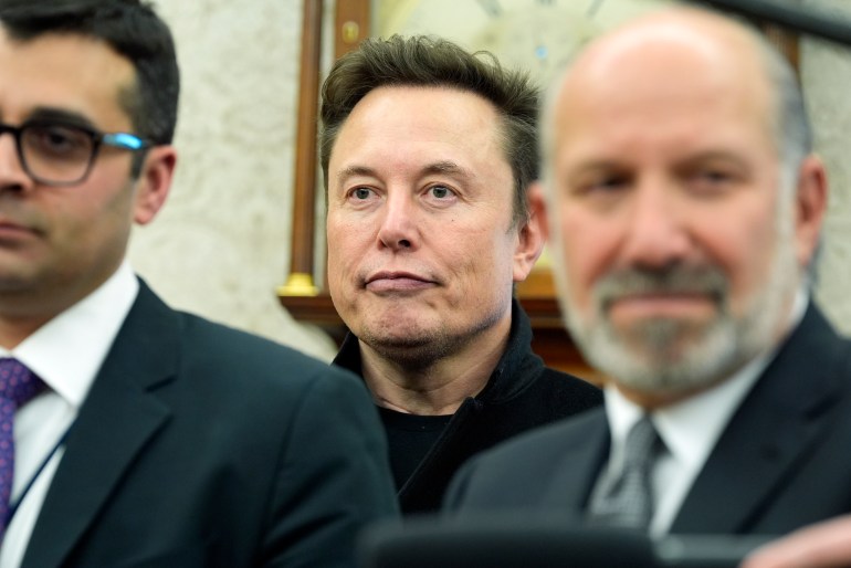 Elon Musk bakom tjänstemän på Oval Office.