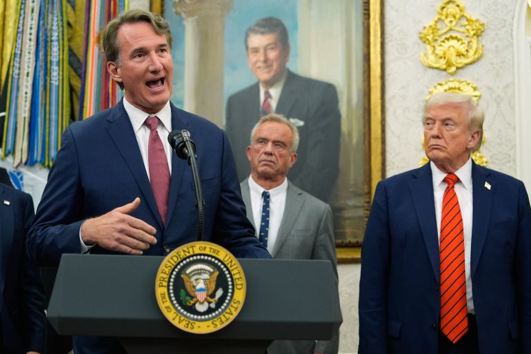 Glenn Youngkin talar på Oval Office när Trump ser på.