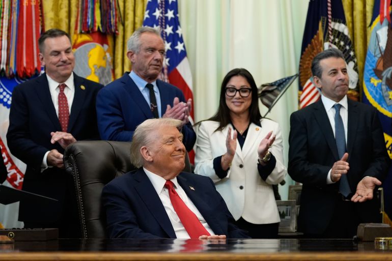 Tjänstemän applåderar Donald Trump i Oval Office.