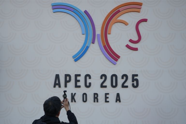 En man filmar logotypen för Asia-Pacific Economic Cooperation Summit (APEC) utanför lokalen i Gyeongju, Sydkorea, tisdagen den 28 oktober 2025. (AP Photo/Lee ​​Jin-man)