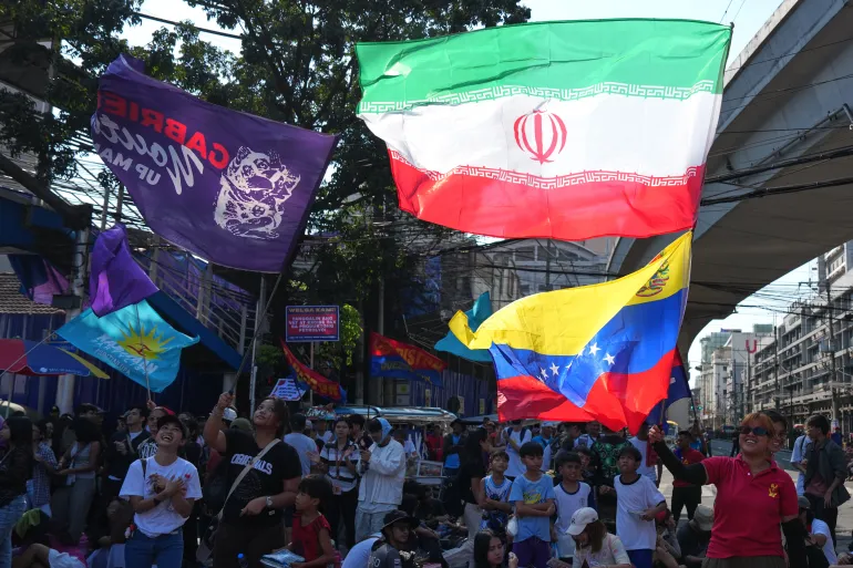 Demonstranter viftar med en iransk flagga under en demonstration av transportarbetare och aktivister som protesterade mot ökningen av oljepriserna fredagen den 27 mars 2026, nära presidentpalatset Malacanang i Manila, Filippinerna. (AP Photo/Aaron Favila)