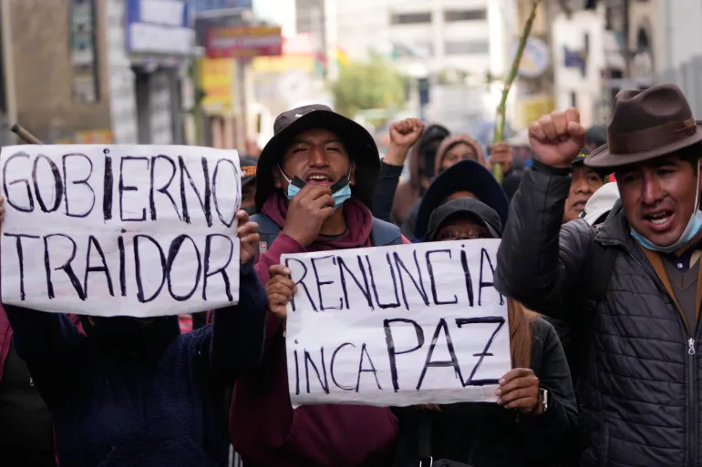 Anti-regeringsdemonstranter håller skyltar som läses på spanska "Avgå Paz," och "Förrädarregering" hänvisar till president Rodrigo Paz i La Paz, Bolivia, måndagen den 18 maj 2026