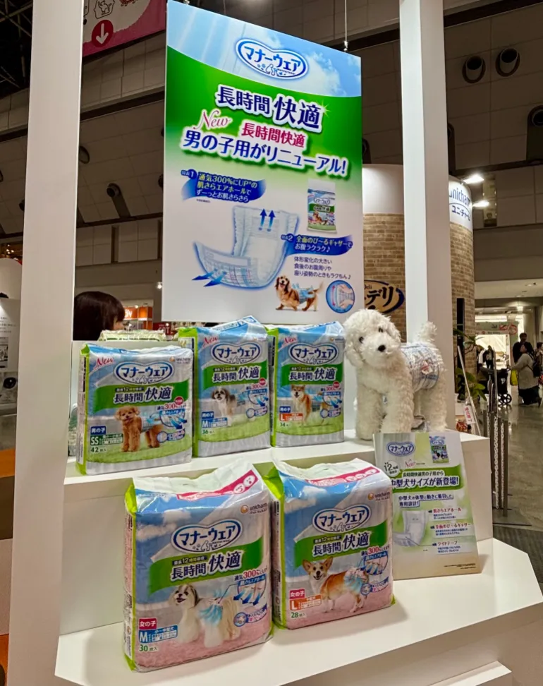 Hundar poserar i välinredda husdjursvagnar på Interpets Conference på Tokyo Big Sight Conference Centre den 5 april 2026." För de två andra är de båda från Unicharms monter på Interpets-konferensen, men jag tog dem den 3 april 2026. Samma plats.