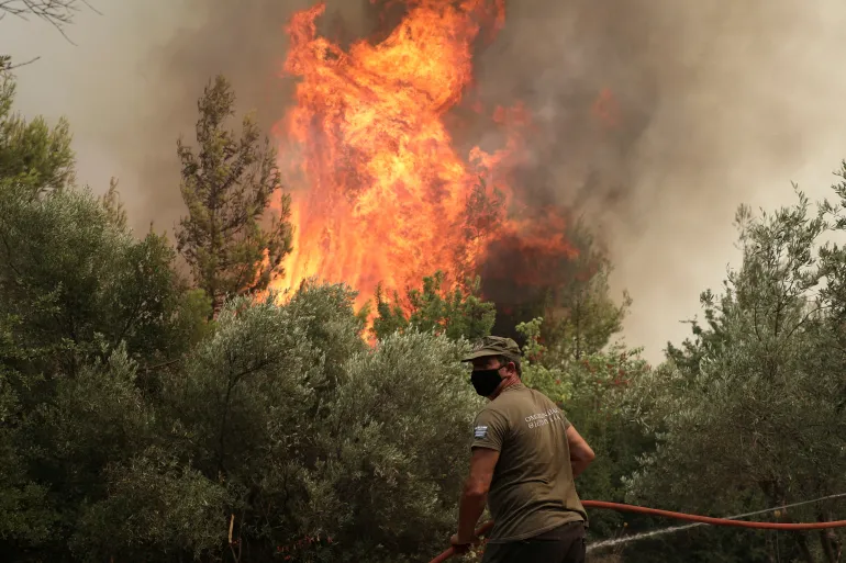 En brandman försöker släcka en brand i byn Avgaria, på ön Evia, Grekland, den 10 augusti 2021. REUTERS/Stelios Misinas