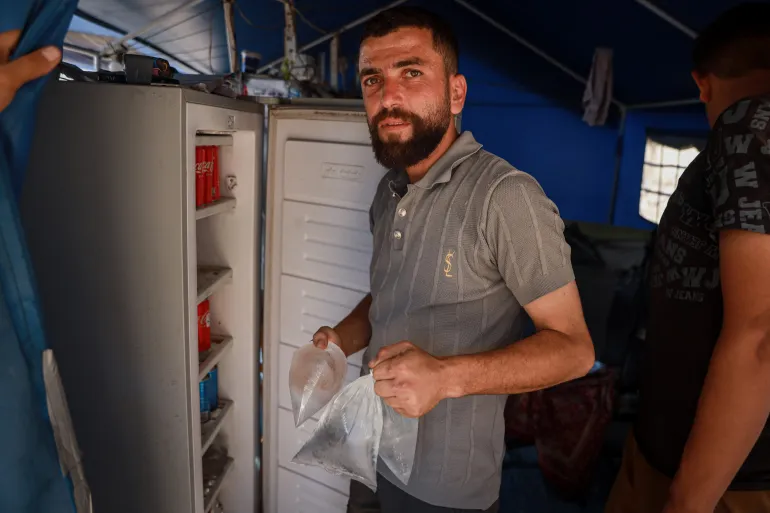 Mohammad Al-Zaanin driver en frystjänst i ett läger i centrala Gaza City, kylvattenpåsar, drycker och andra föremål för fördrivna familjer mot en avgift [Abdelhakim Abu Riash/ Bladet]