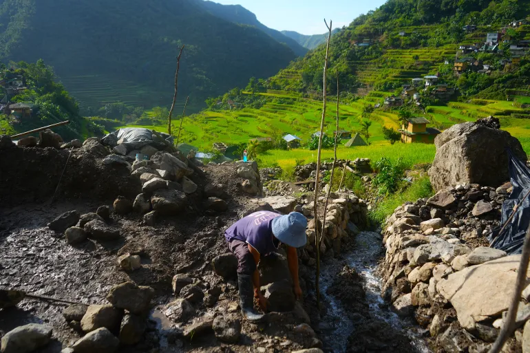 Batad-boen Joel Langihon, 52, ordnar högar med stenar och lera för att befästa en skadad del av hans familjs risfält som spolades ut till följd av Super Typhoon Fung-Wong i november förra året