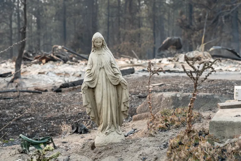 En staty av Jungfru Maria står orörd framför ett utbränt bostadshus i stadsdelen Balboa i Spokane, Washington, den 2 augusti 2026.