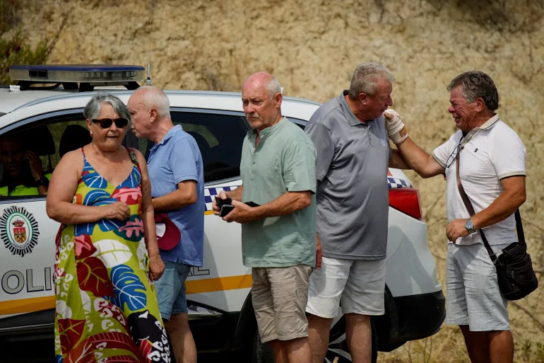 Invånare som drabbats av dödliga skogsbränder väntar på tillträde från polisen för att kunna återvända till sina hem i Bedar, Almeria, Spanien, 12 juli 2026. REUTERS/Ana Beltran