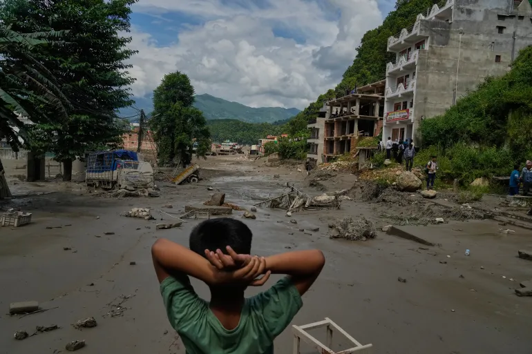 En pojke tittar på förödelsen som orsakats av snabba översvämningar längs floden Trishuli i Nepals Nuwakot-distrikt, onsdagen den 26 augusti 2026. (AP Photo/Niranjan Shrestha)
