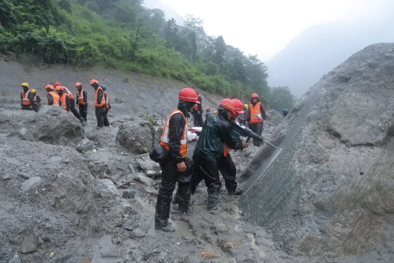 Ett odaterat utdelningsfoto av räddningsarbetare som deltar i en räddningsoperation nära tunneln i Trishuli 3A Hydropower Project, efter dödliga översvämningar och lerskred, i Rasuwa, Nepal