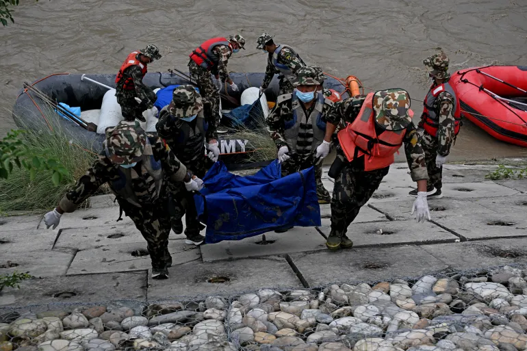 Nepals armépersonal bär kropparna av avlidna översvämningsoffer under en sökoperation längs Narayani-floden vid Bharatpur i Nepals Chitwan-distrikt den 31 augusti 2026. Nepal begravde den 31 augusti några av de hundratals kroppar som hämtades efter en dödlig, tsunamiliknande by som kraschade genom Himalayan-liknande översvämningsområden och översvämningsområden. tusentals fortfarande saknas. (Foto av PRAKASH MATHEMA / AFP)