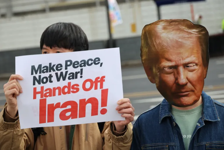 En aktivist som bär en utskuren mask av Trump deltar i en demonstration för att fördöma USA-Israels krig mot Iran, tillsammans med andra framför USA:s ambassad i Seoul, Sydkorea, den 1 mars 2026