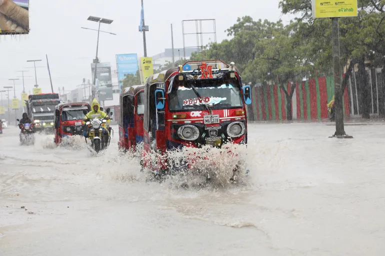 Rickshaw-tuktuker kör genom översvämningsvatten längs gatan KM4 efter ett kraftigt skyfall i Mogadishu, Somalia, 21 juni 2026. REUTERS/Feisal Omar