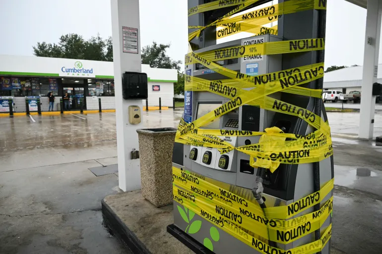 Arbetare spärrar av en bensinpump med gul tejp på en bensinstation i Navarre, Florida, den 9 oktober 2026, när orkanen Isaias rör sig norrut mot Florida Panhandle. [AFP]