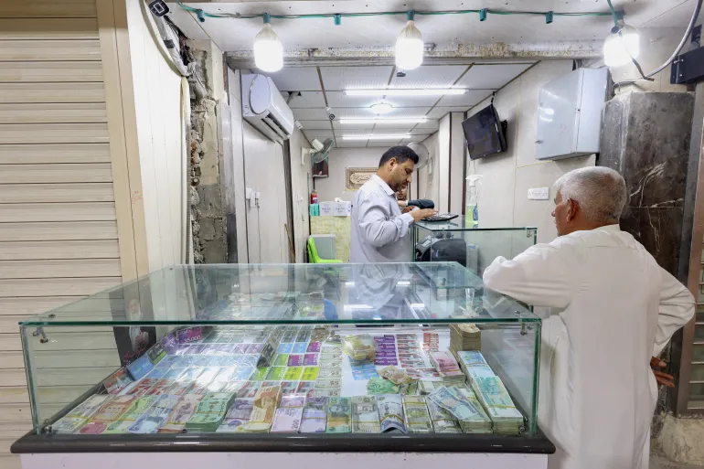 En kund står i en valutaväxlingsbutik i Najaf, Irak, den 7 oktober 2026 [Alaa Al-Marjani/ Reuters]