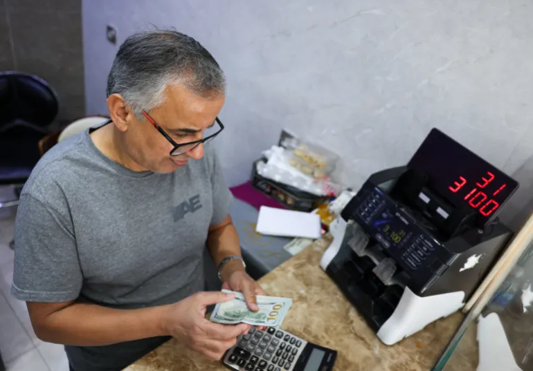 En man räknar amerikanska dollarsedlar i en valutaväxlingsbutik i Bagdad, Irak, 7 oktober 2026 [Ahmed Saad/Reuters]