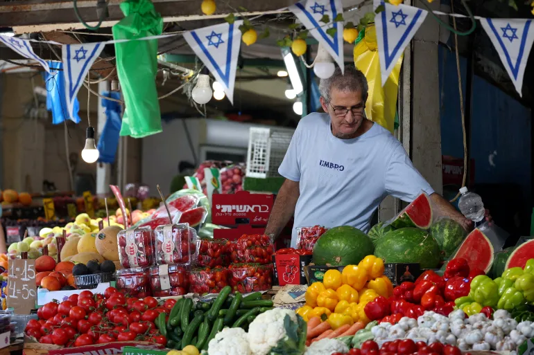 En israelisk man tar hand om sin butik i Haifa, Israel, den 24 juni 2025