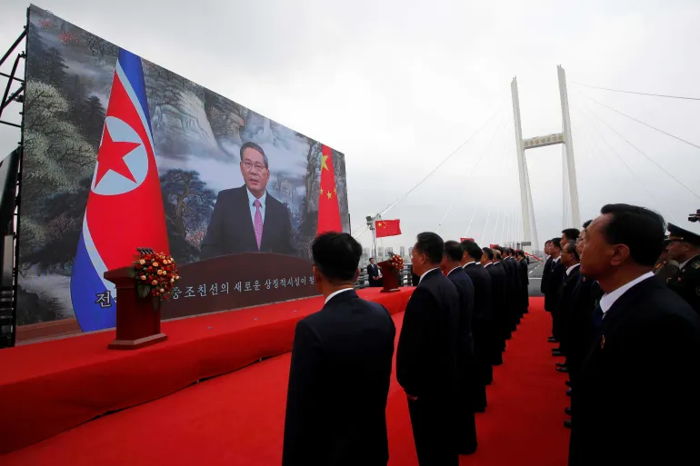 Kinas premiärminister Li Qiang, på skärmen, håller ett tal genom videokonferens när en ny bro mellan Kina och Nordkorea öppnas i North Phyongan-provinsen, Nordkorea, torsdagen den 15 oktober 2026
