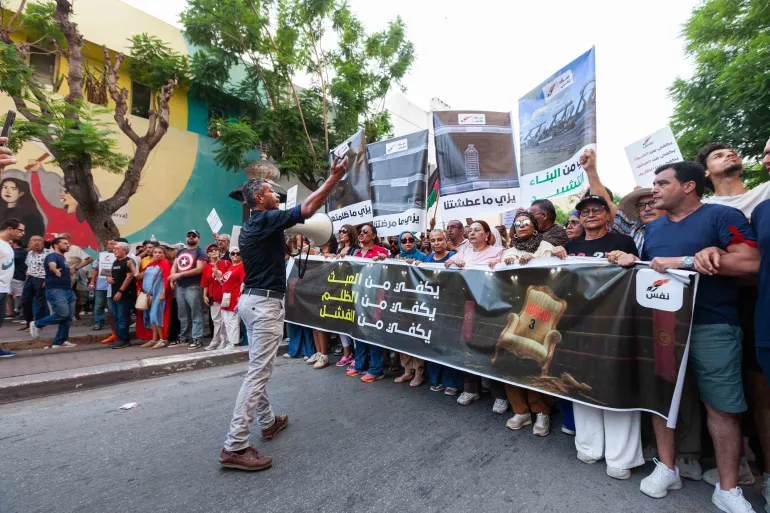 Människor protesterar mot stigande priser, sjunkande köpkraft och brist på basvaror i Tunis, Tunisien, torsdagen den 20 augusti 2026. Banderollen på arabiska lyder: