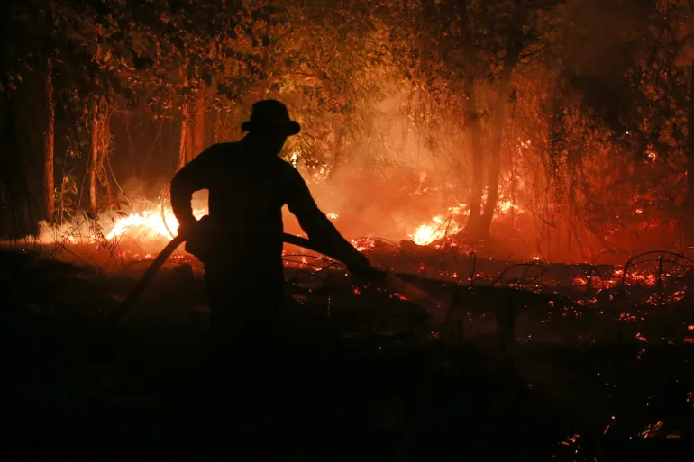 En brandman sprutar vatten i ett försök att släcka en skogsbrand som brinner genom en torvskog i Pulang Pisau, Centrala Kalimantan, Indonesien, den 5 september 2026